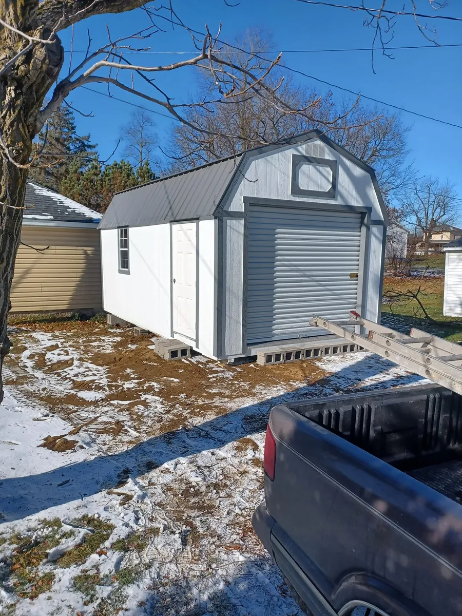 Two photos: navy lofted barn shed in snow