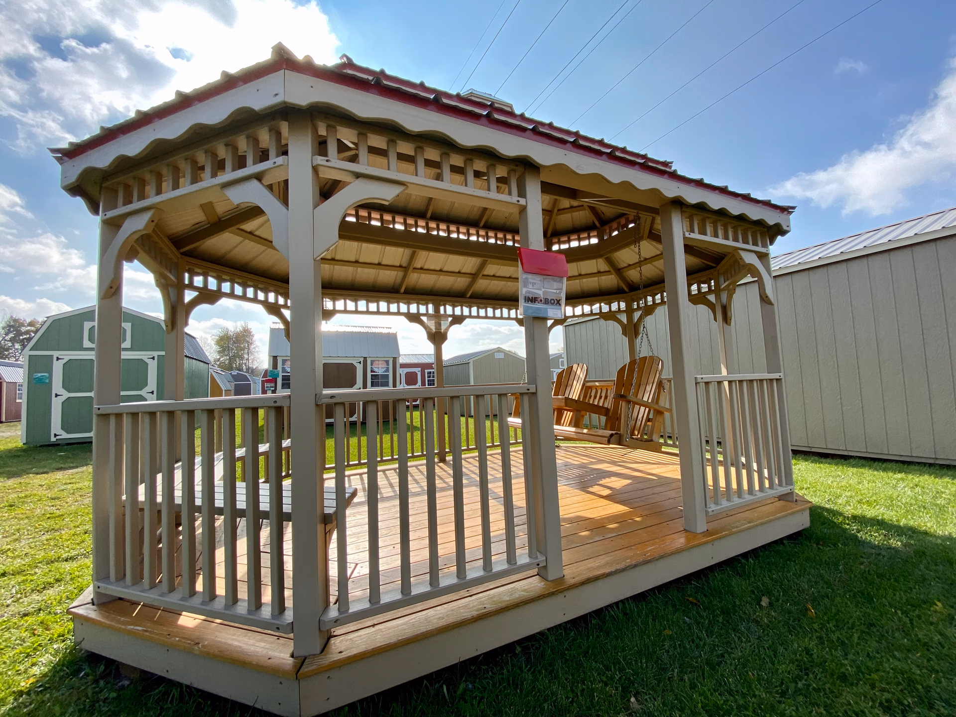 Double-roof gazebo in cream with red trim and Adirondack chairs